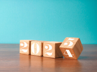 Flipping wooden cubes with the Year number 2024 and 2025, New Year concept