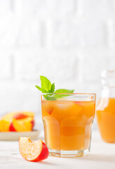 Homemade peach and nectarine ice and mint lemonade on a light table. Cold drink, sugar free. Vertical orientation.