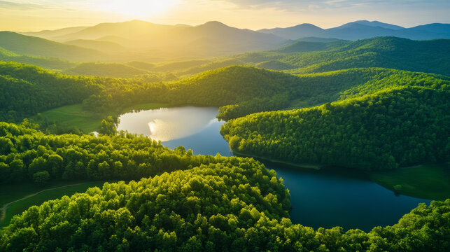 "A beautiful landscape of green mountains and a lake in the morning with a sunrise sky. This nature scene showcases a watershed forest, highlighting water and forest sustainability. The aerial view re