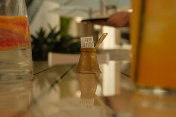 A small gold vase with a piece of paper inside it