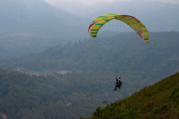 Some people are paragliding on a mountain with beautiful views