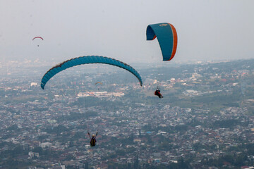 Some people are paragliding on a mountain with beautiful views