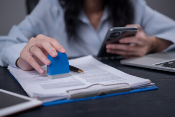 woman hand stamping a document, signifying approval or verification in an office setting. Ideal for legal, business, or administrative