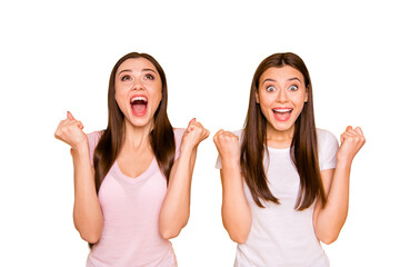 Unexpected luck! Portrait lucky cheerful positive millennial girls trip beautiful feel satisfied scream shout yeah raise fists impressed long hair light t-shirts isolated yellow background