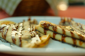 Pancakes covered with chocolate cream on a white plate