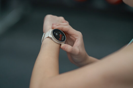 Young woman workout in gym using smart watch and application.