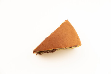 That is a triangular slice of Bolu, likely a chocolate-filled sponge cake, isolated on a white surface. A soft and sweet treat.