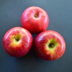 A view of three Pink Lady apples on the table. 