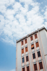 Fototapeta premium Bâtiment à Verbania avec un ciel nuageux. Contre plongée d'un immeuble en Italie. Ciel moutonneux et immeuble. Appartements en Italie. Résidence populaire