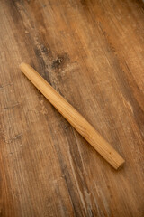 a wooden rolling pin for dough lies on the table