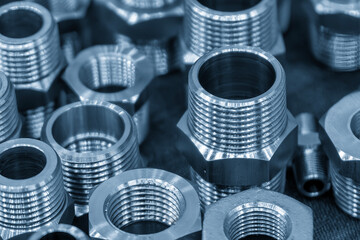 The pile of steel water pipe connector parts in the light blue scene.