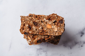 Healthy nuts and seed bread on white marble background.
