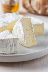 Camembert Cheese Wheel on a Light Plate with a Slice Removed, Soft Cheese Texture