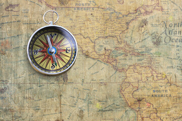 Classic round compass on background of old vintage map