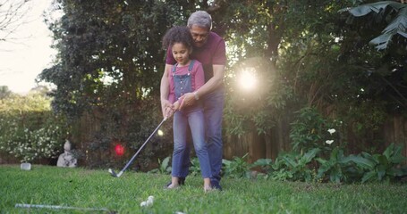 Learning, teaching and bonding of a grandfather showing a little girl a golf player swing outside. Active, playing and leisure activity of a loving family having fun together in an outdoor garden