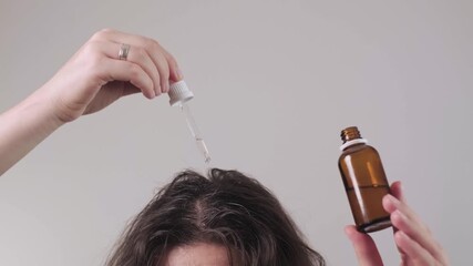 Home spa treatments: girl holding a scalp massager and hair oil, essential accessories for maintaining scalp and hair hygiene.