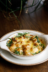  delicious dish with crispy potatoes, fresh vegetables, fragrant herbs, and creamy cheese on a beautiful black plate in a cozy, charming café.
