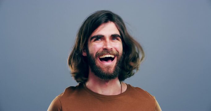 Funny, face and man in studio laugh with happiness, freedom or reaction to crazy joke. Model, portrait and person with comedy, comic or lol emoji with humor and smile in grey background or mockup