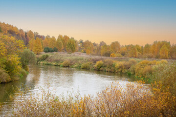 Autumn forest on the river bank. Forest river in autumn. Autumn forest river. Autumn river forest landscape