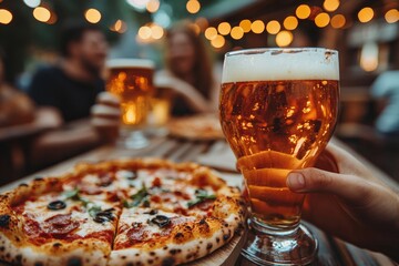 Group of friends enjoying pizza and beer outdoors in a cozy evening setting.