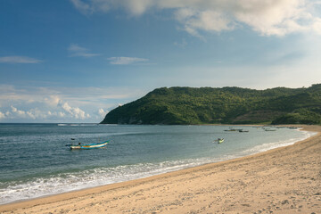 A fishermen's boats at sandy beach by the coast bay of a tropical island