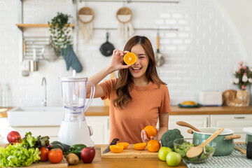 Portrait of beauty healthy asian woman making orange fruit smoothie with blender.girl preparing cooking detox cleanse with fresh orange juice in kitchen at home.health, vitamin c, diet, healthy drink