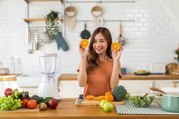 Portrait of beauty healthy asian woman making orange fruit smoothie with blender.girl preparing cooking detox cleanse with fresh orange juice in kitchen at home.health, vitamin c, diet, healthy drink