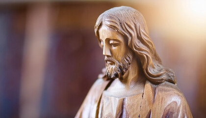 Close-up of wooden Jesus Christ wooden sculpture. Handmade art. Religion and faith