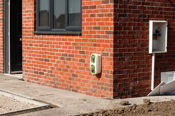 New eco-friendly home installation featuring green energy unit against  modern brick facade in bright sunlight