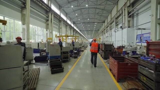 This is a scene depicting a manufacturing floor bustling with workers in an industrial setting. Stock Clip
