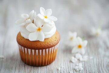 Delicate vanilla cupcake with white floral frosting on wooden background