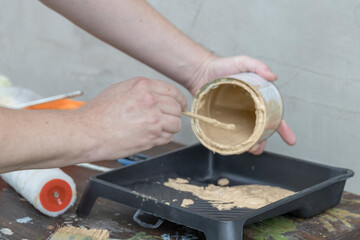 A person is painting a wall with a can of paint