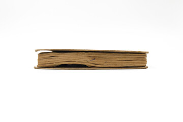 side view of a worn brown book, isolated on a white background