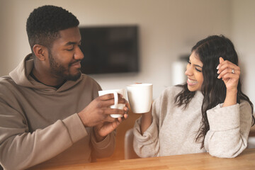 couple shares a joyful moment, cozy morning connection over coffee at home with smiles and laughter