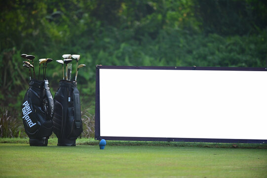 Blank billboard white screen posters billboard for advertising Sponsor in Golf course with a bag of golf clubs beside it
