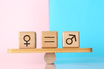 Gender equality concept. Cubes with male and female symbols on scales against color background