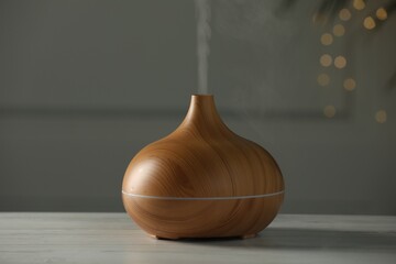 Aroma oil diffuser on white wooden table