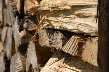 dried brown wooden firewood neatly stacked in a pile