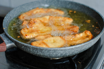 Fried banana in a pan with hot oil. Banana deep fried is a popular street food in Indonesia