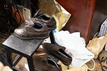 stylish brown shoes with shoe extender in an old cluttered shoe repair shop. vintage style...