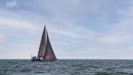 Obraz premium A yacht in the open sea against a background of blue sky.