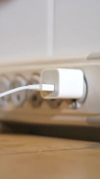 Vertical view plugging and unplugging a USB power adapter or charger.	