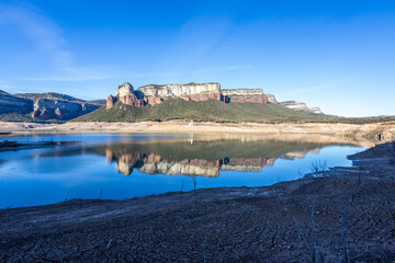 Obraz premium Lack water Sau Reservoir. The swamp is at very low water levels due to lack of rain. Desertification, climate change, environmental problems, drought. Barcelona, Spain