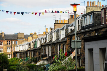 Charming terraced houses with festive bunting on a quiet Edinburgh street.