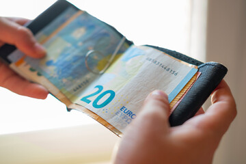 Teen holding wallet with Euro bills, symbolizing pocket money, savings or planning for future dreams, currency handling, monetary value