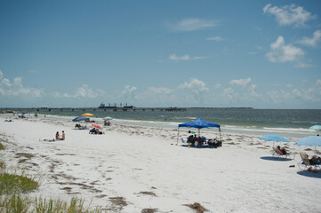 Obraz premium Wide-angle view of Fort DeSoto Park, Pinellas County, Florida, Looking over the sea oats and sandy beach with people, towards the Gulf of Mexico, Sunny day with blue sky and white clouds, Wide angle 