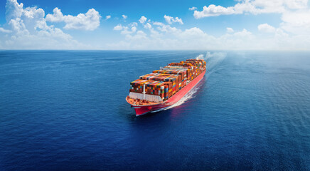 Aerial view of a very large container cargo ship traveling with speed over the ocean as a concept...