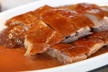 Delicious roasted golden goose is cut into pieces and placed on a plate