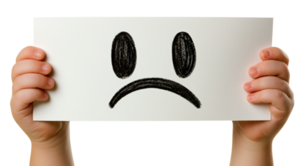 Child holding paper with sad face drawing indoors