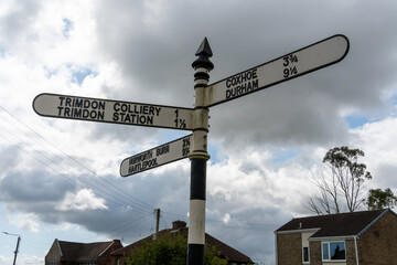Fototapeta premium Trimdon, County Durham, UK. Signpost in the village showing distances to other places nearby,